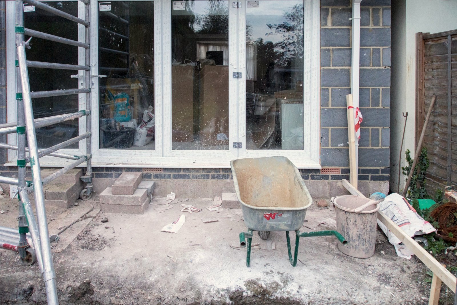 Casa em obra de ampliação, com paredes de bloco e entulho no quintal
