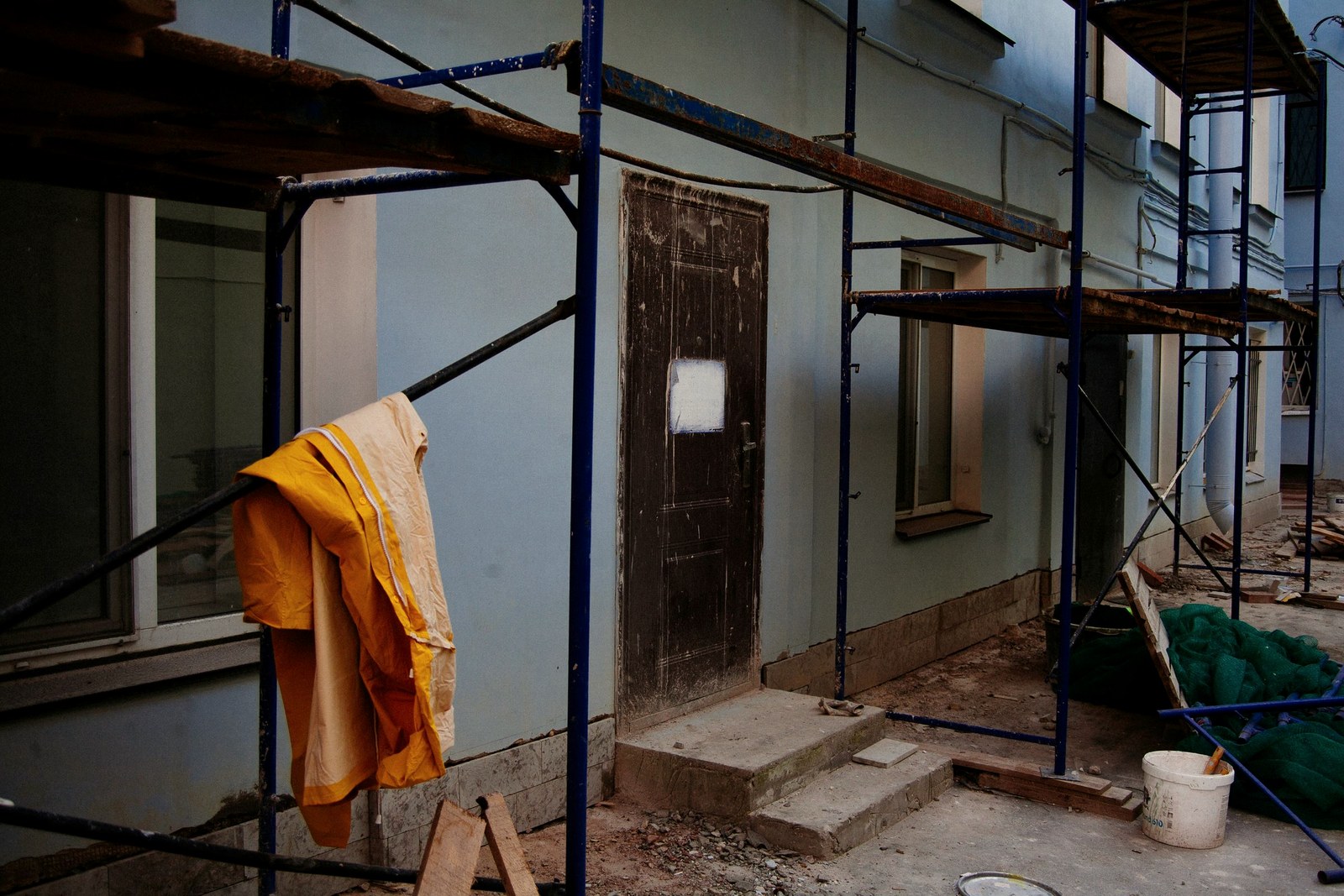 Fachada de casa em obra com andaimes durante a regularização