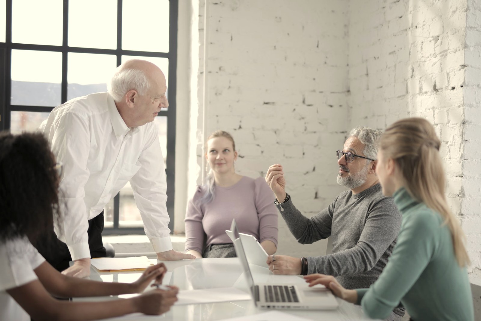 Pessoas reunidas em volta de uma mesa conversando sobre regras